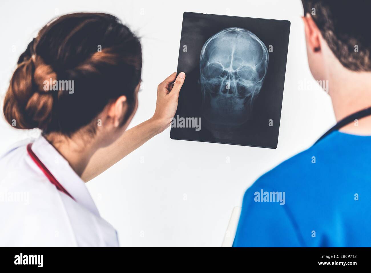 Female doctor looking at x ray film of patient head injury while