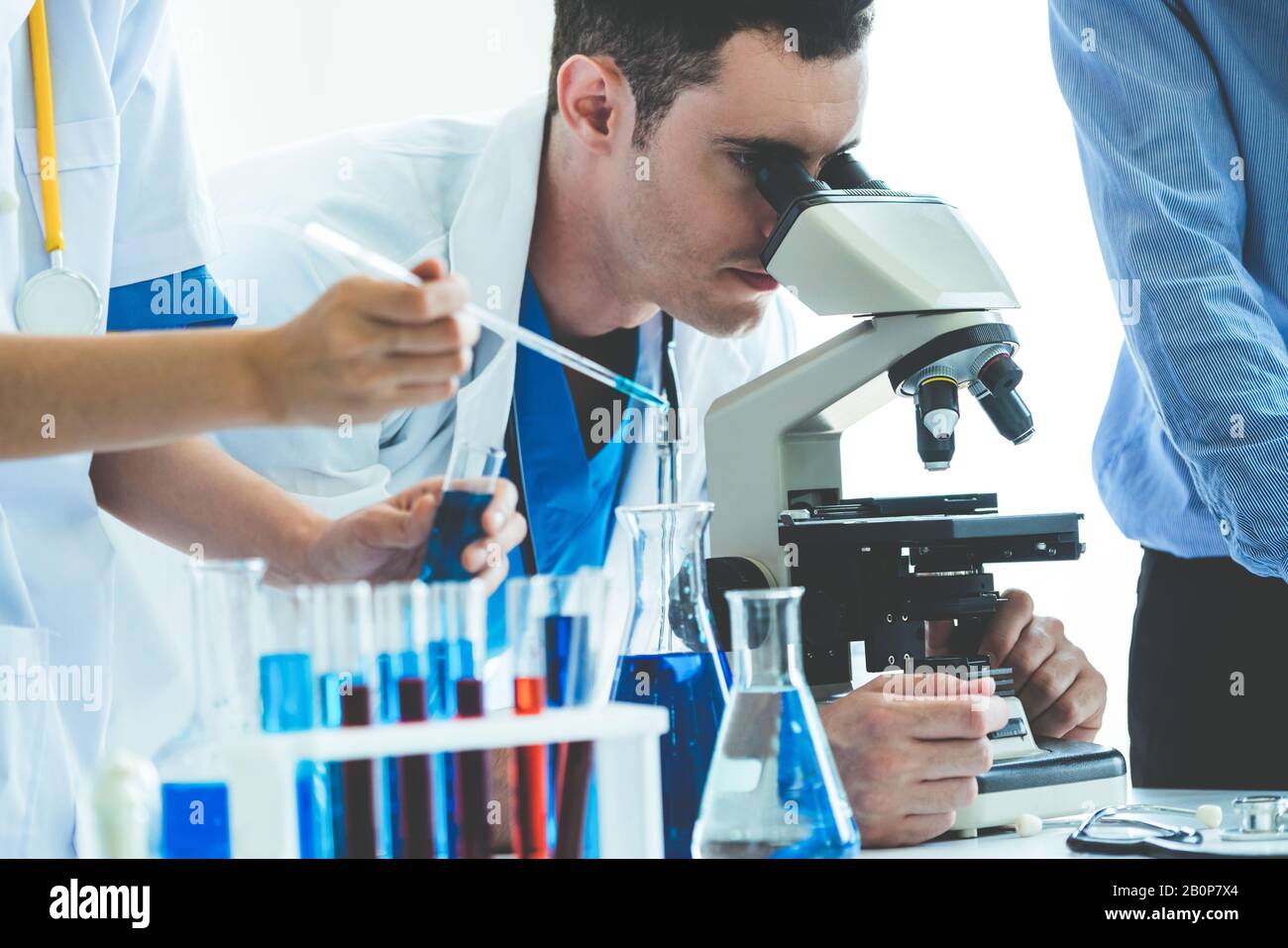 Group of scientists wearing lab coat working in laboratory while
