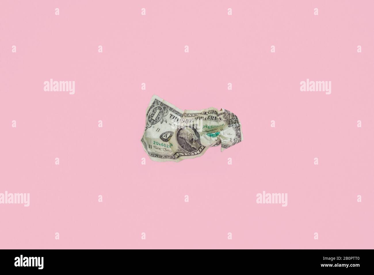 crumpled up dollar bill  on pink background Stock Photo