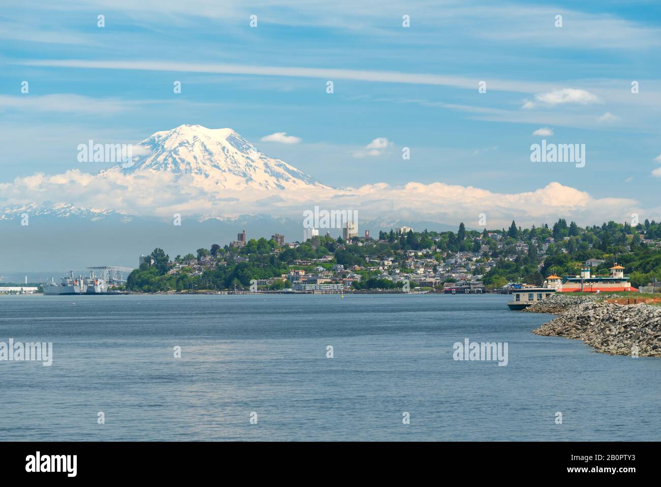 Mt Rainier Hovers Over Downtown Tacoma and Commencement Bay as Seen from Point Ruston with people walking and Riding Bikes Stock Photo