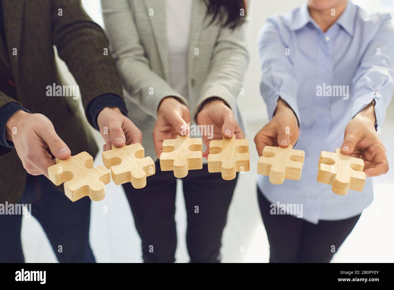 Crop formal people showing wooden jigsaw puzzle pieces Stock Photo Alamy