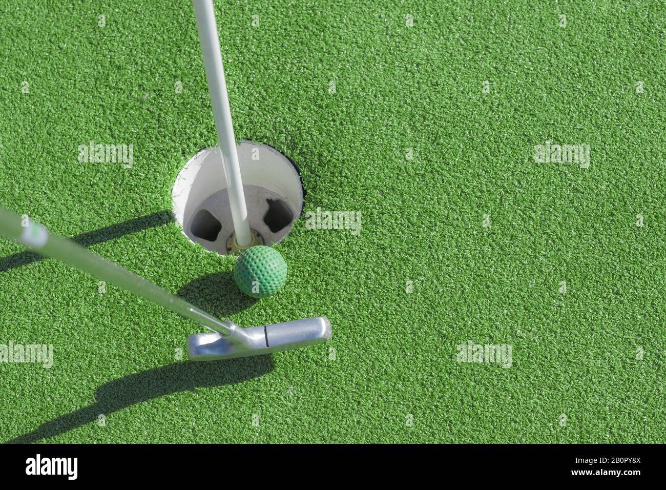 Mini golf club, ball and hole Stock Photo