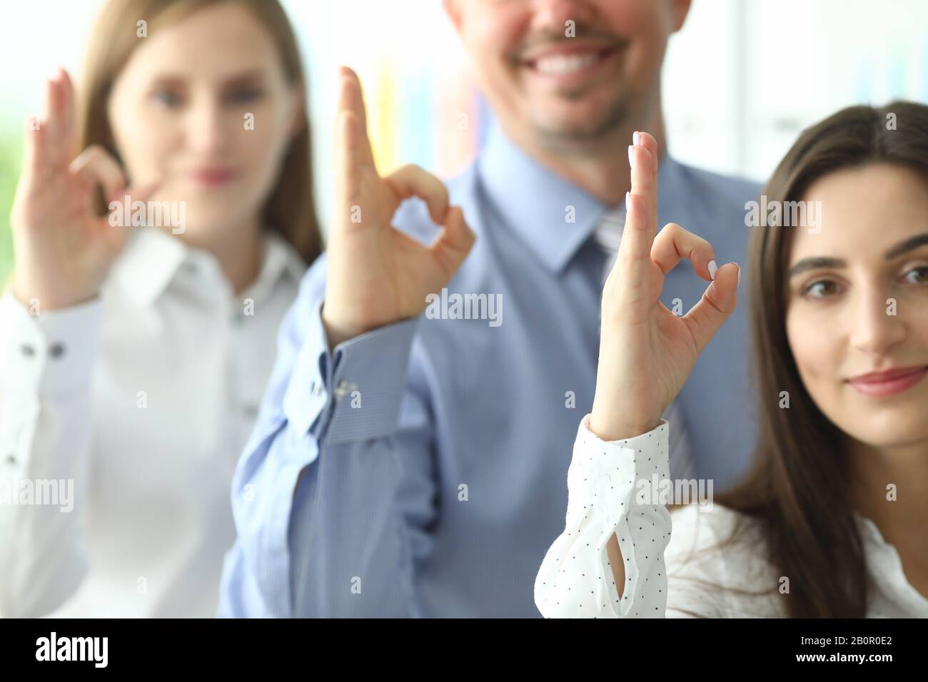 Team showing okay sign Stock Photo - Alamy