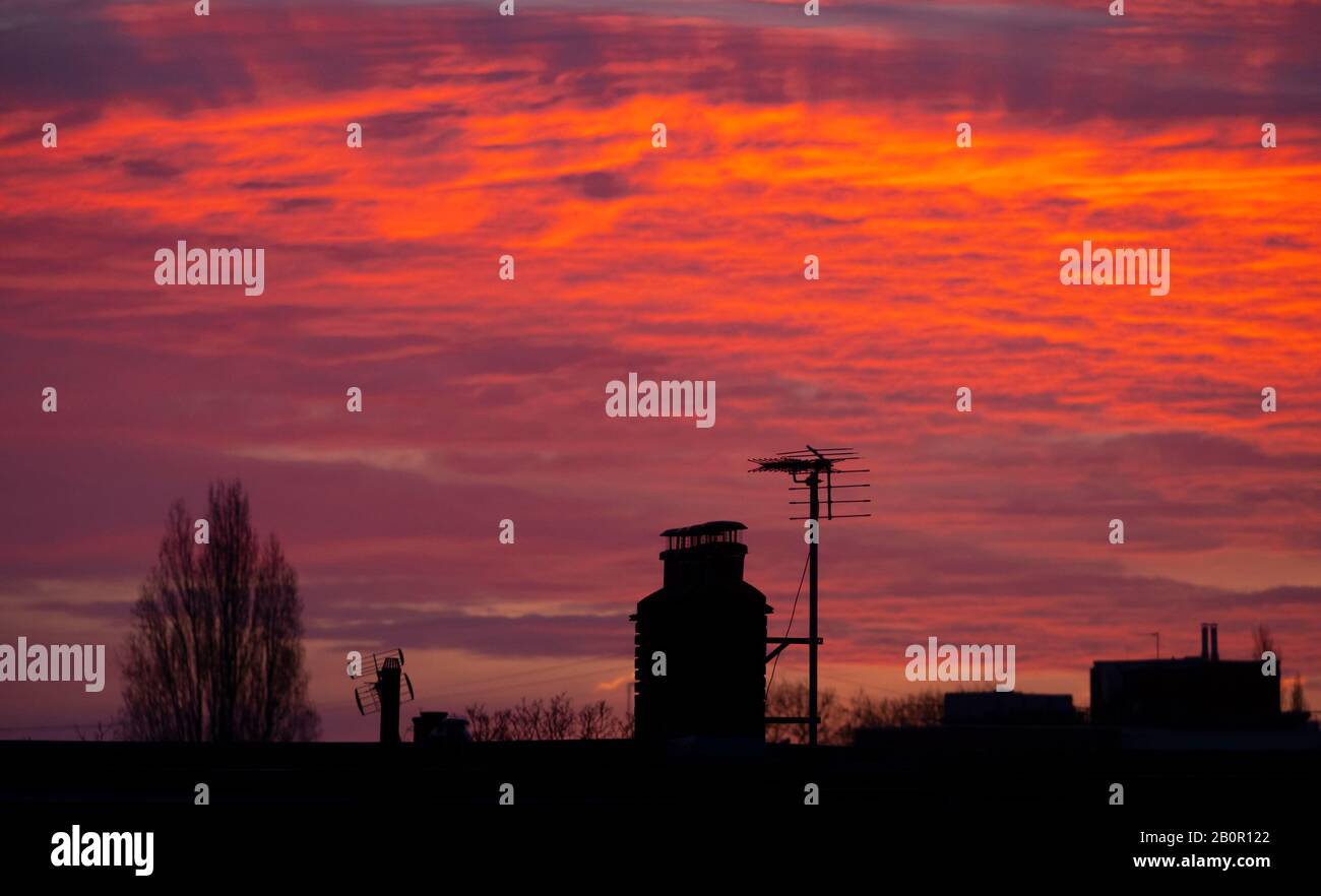 Wimbledon, London, UK. 21st February 2020. Rooftops silhouetted against a bright red sky before sunrise in south west London. Credit: Malcolm Park/Alamy Live News. Stock Photo