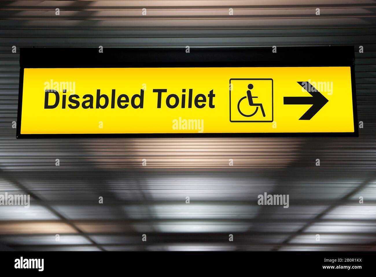 sign with arrow point to disabled toilet at the airport for passenger with impaired body. universal design for elderly or the disabled in public place Stock Photo