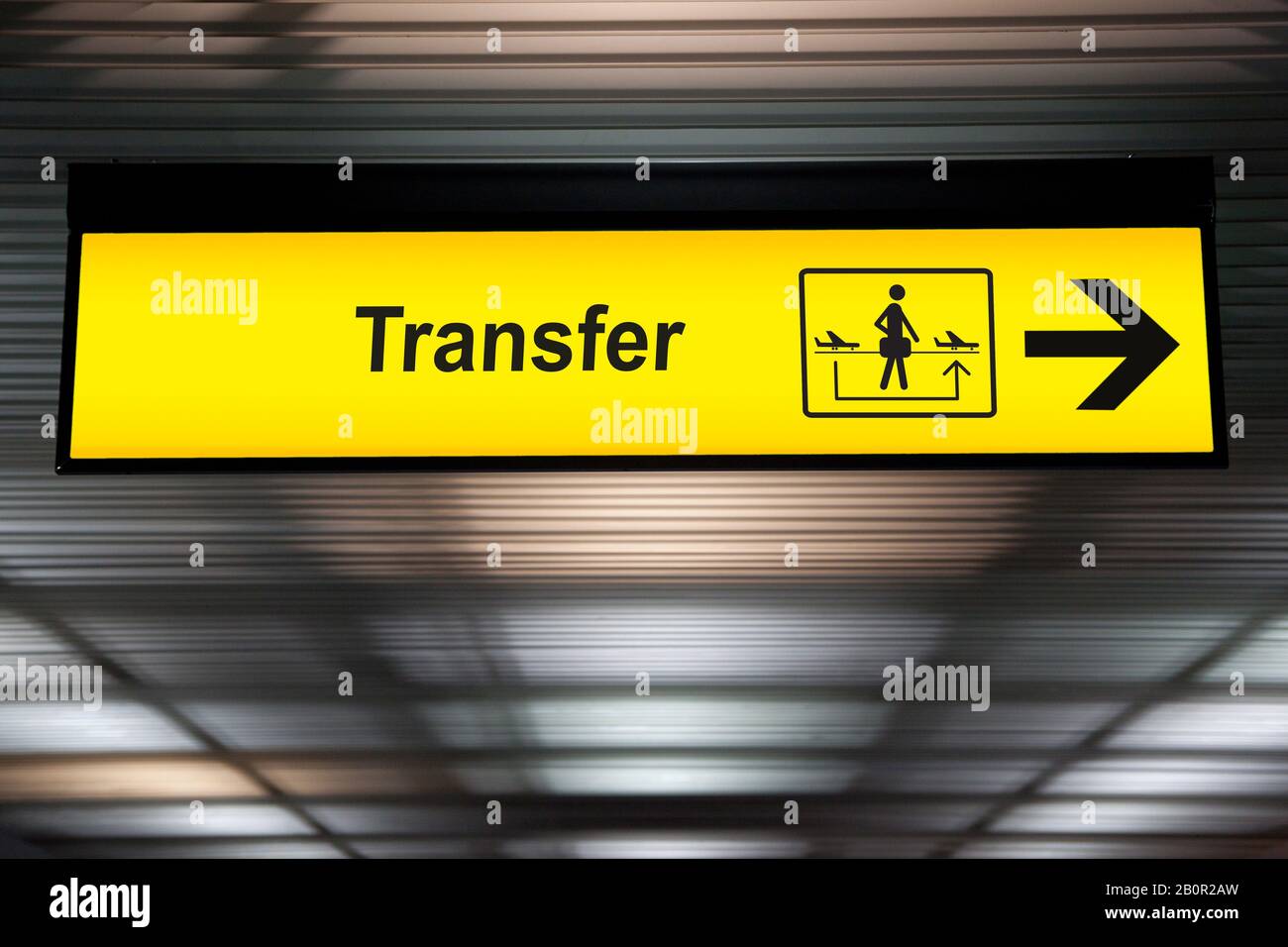 sign transfer with arrow for direction for transit passenger to change air plane for destination. yellow transfer for connecting flight sign at the ai Stock Photo