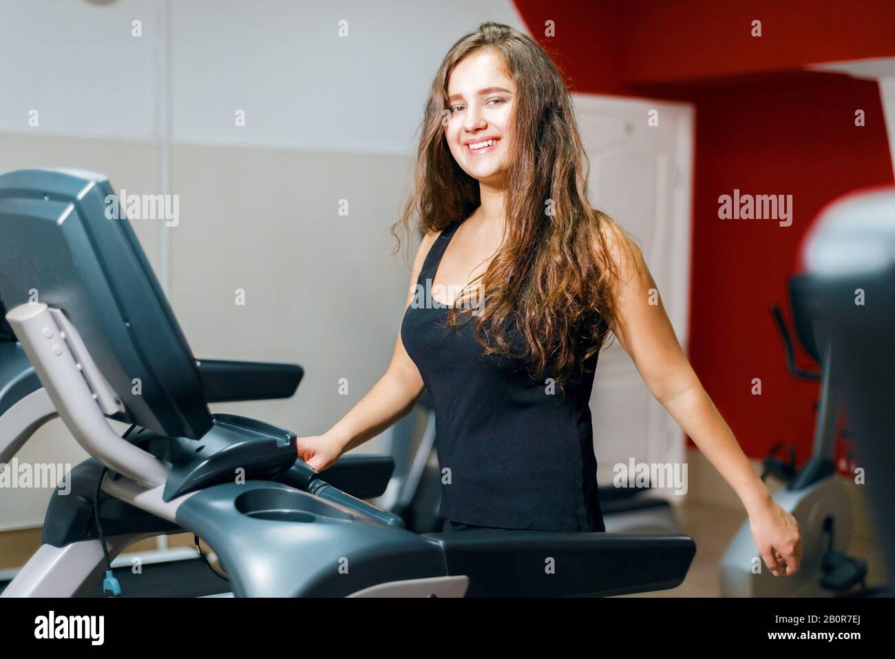 young beautiful girl trains on treadmill. sports woman engaged in fitness. aerobic training Stock Photo