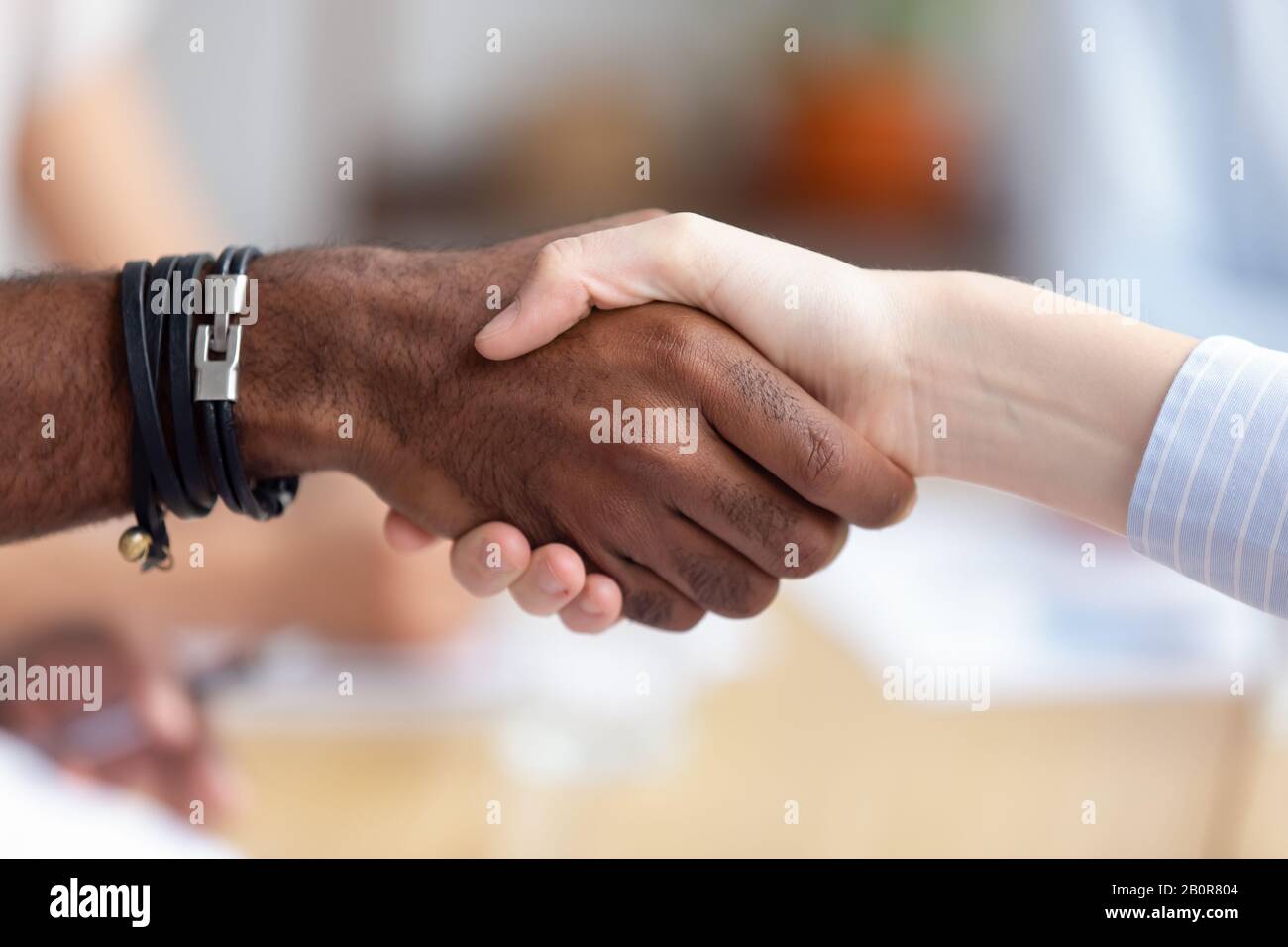 Close up African American businessman shaking hand of colleague at company meeting, greeting, getting acquainted, start working together, business par Stock Photo