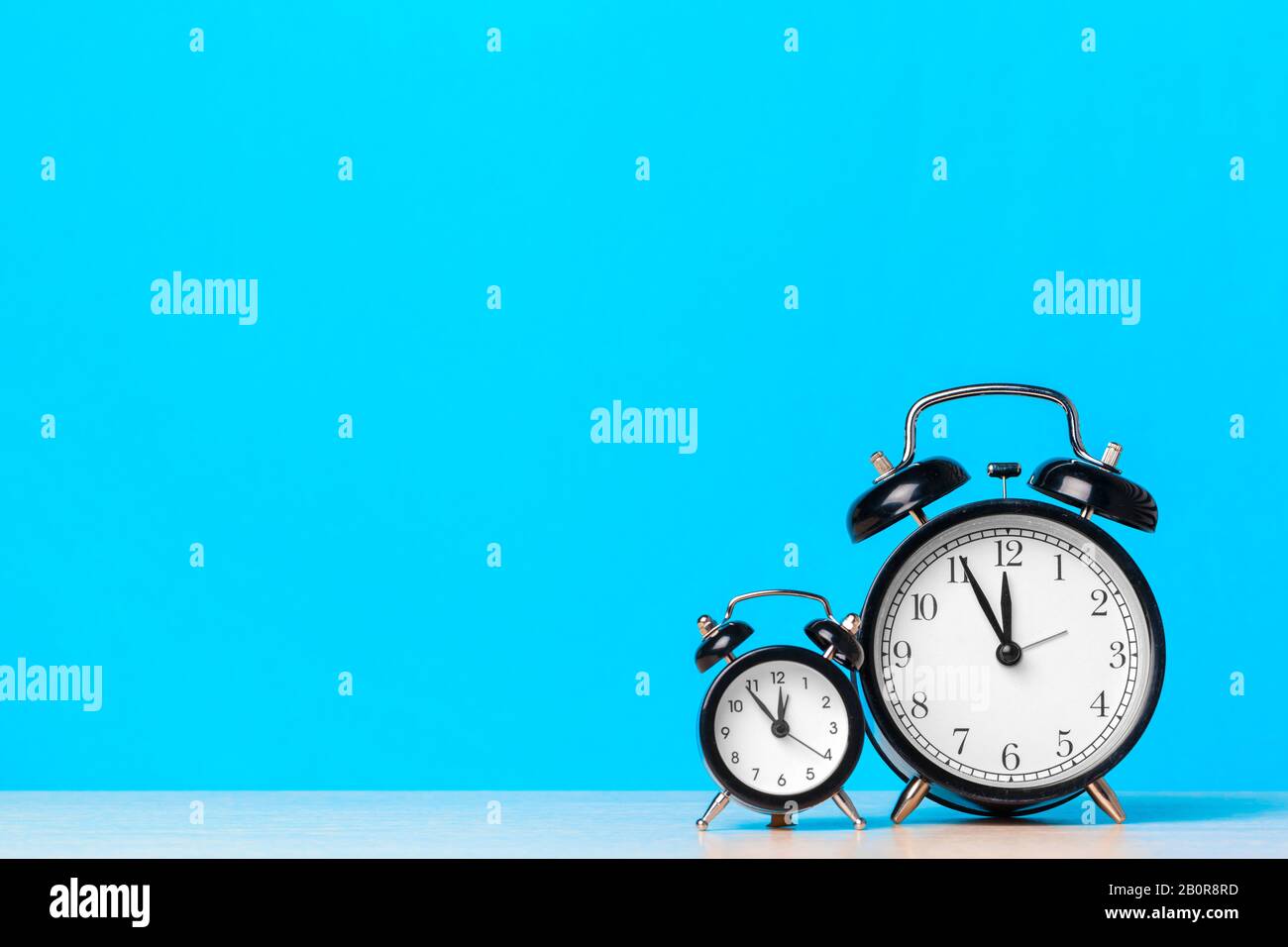 Different alarm clocks on table. Time change concept Stock Photo