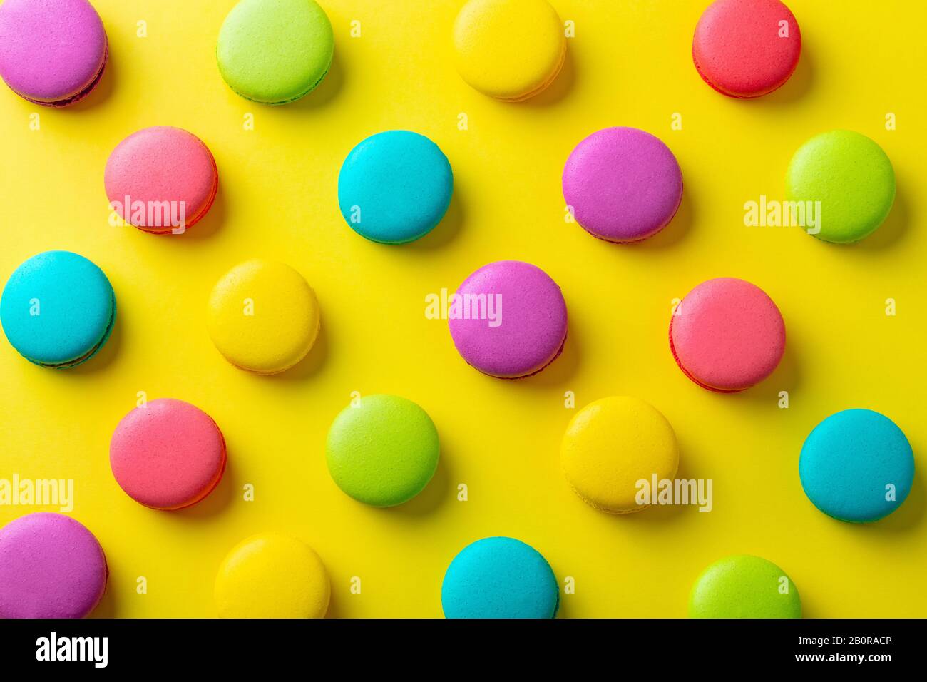 Macaroons dessert on yellow background. Flat lay composition. Top view. Stock Photo