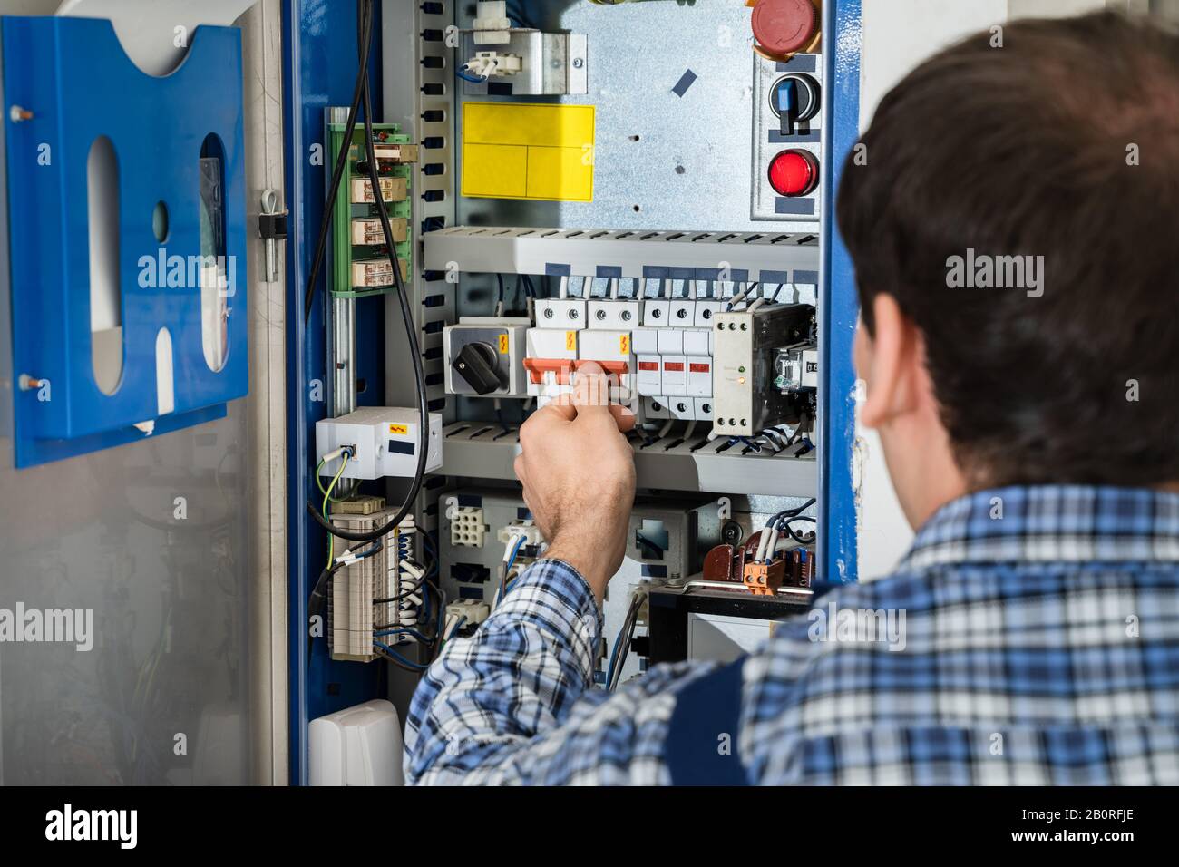 Photo Of Young Male Technician Examining Fusebox Stock Photo