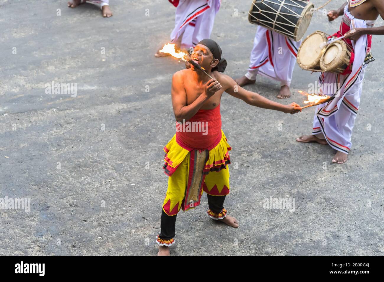 Matale, Sri Lanka: 03/18/2019: Fire eater enteraining tourists with a display of drums and fire eating. Stock Photo