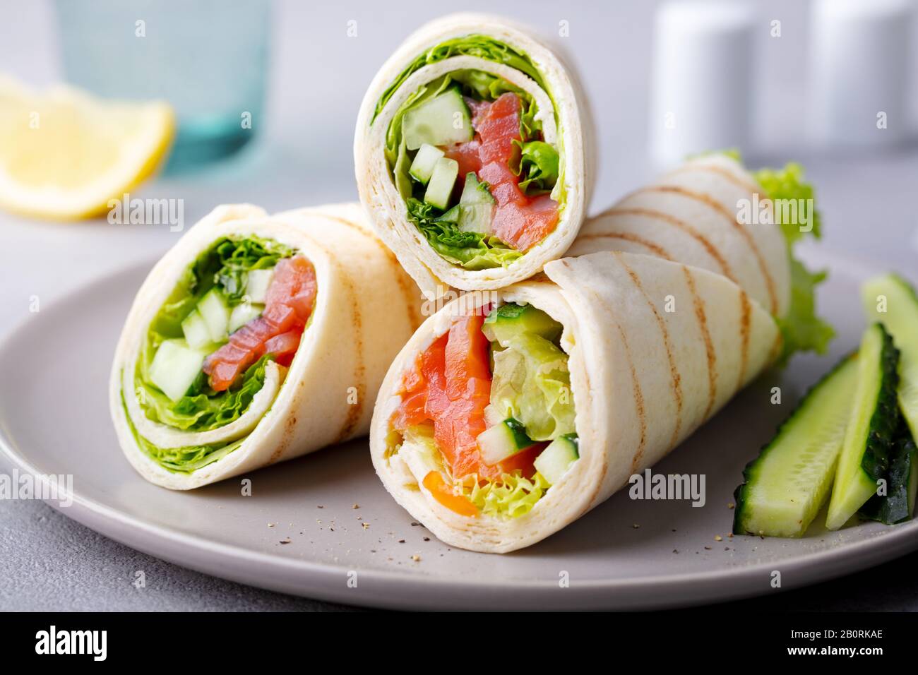 https://c8.alamy.com/comp/2B0RKAE/wrap-sandwich-roll-with-fish-salmon-and-vegetables-grey-background-close-up-2B0RKAE.jpg