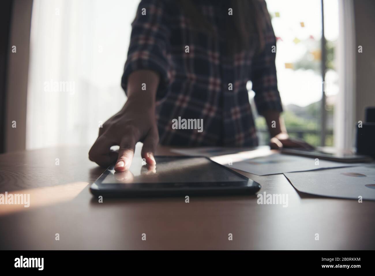 Female hand touching tablet display on table. Stock Photo