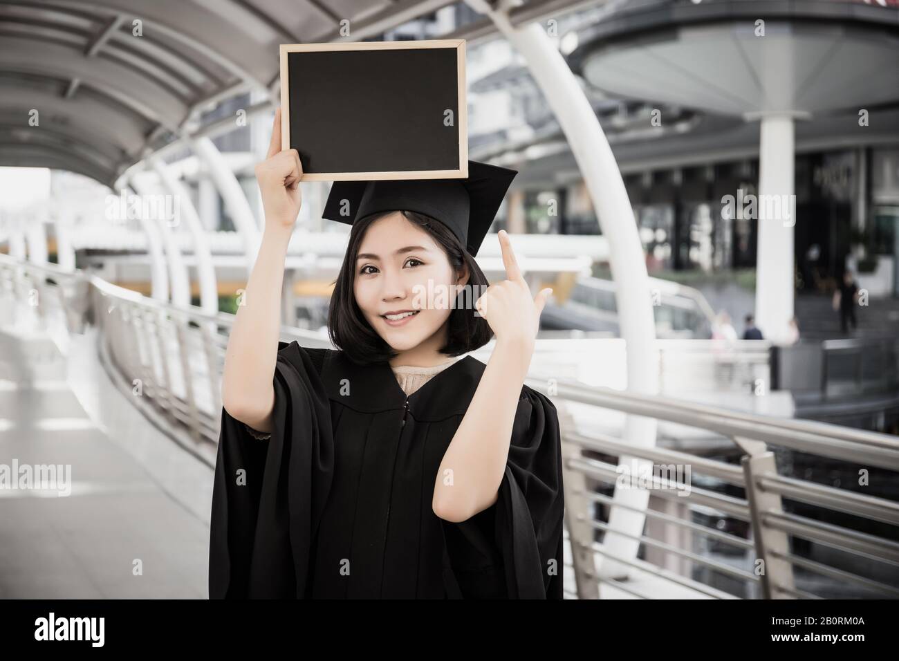 Female graduate holding placard hi-res stock photography and images - Alamy