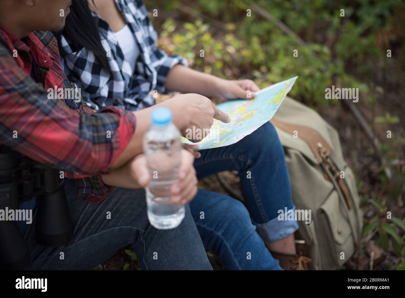 Young couple hikers looking a map in the forest Stock Photo - Alamy