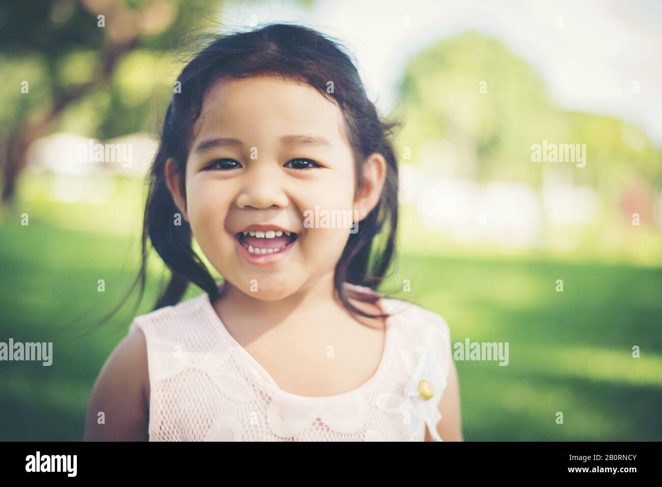 Portrait of little girl smiling showing happy in the park Stock Photo ...