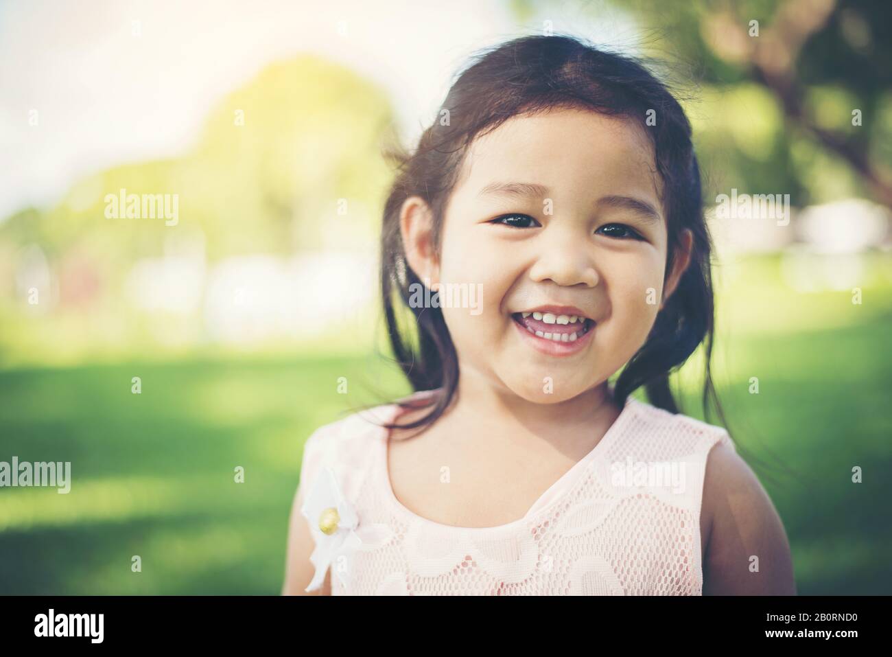 Portrait of little girl smiling showing happy in the park Stock Photo ...