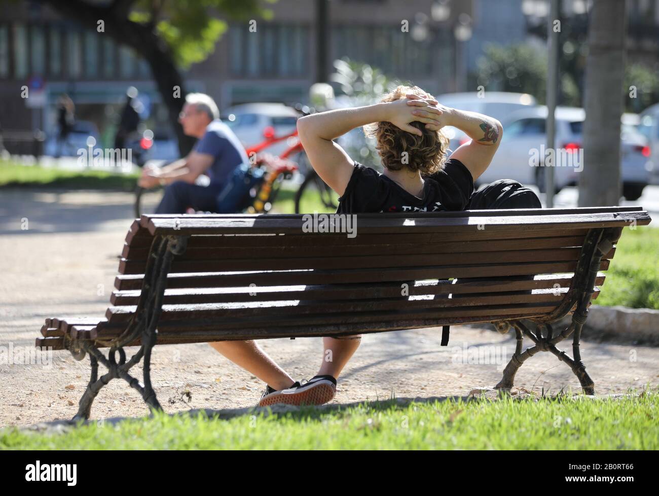 Some people sunbathing in a sunny day in a green area inside the Valencia city, Spain. Stock Photo