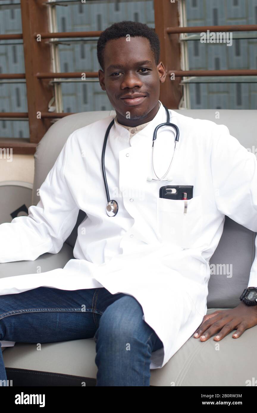 doctor in white coat sitting in an armchair with a stethoscope on his