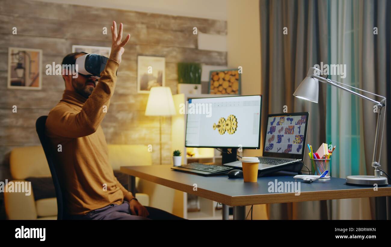 Bearded engineer using virtual reality headset to create new gear system. Stock Photo