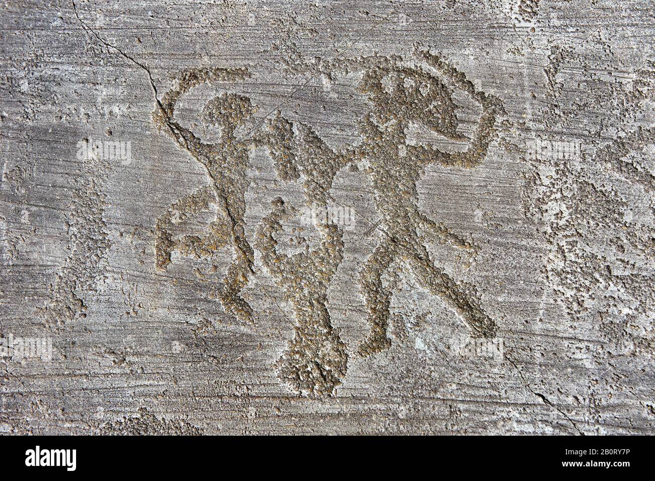 Petroglyph, rock carving, of two warriors fighting, the one on the right has a headress and they both have shields. Foppi di Nadro, Riserva Naturale Stock Photo