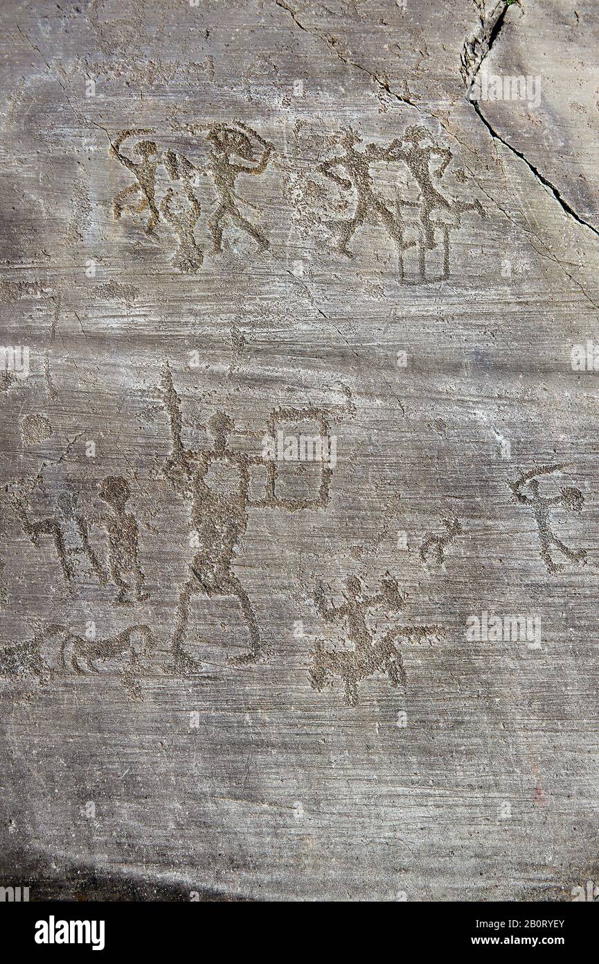Petroglyph, rock carving, of warriors fighting and rifing a horse. Carved by the ancient Camunni people in the iron age between 1000-1200 BC. Rock no Stock Photo