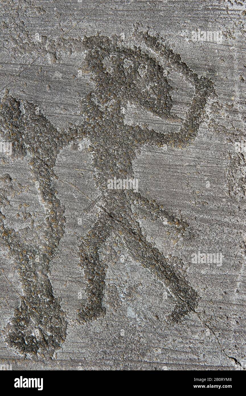 Petroglyph, rock carving, close up of a warrior fighting, he has a headress and they both have shields. Carved by the ancient Camunni people in the ir Stock Photo