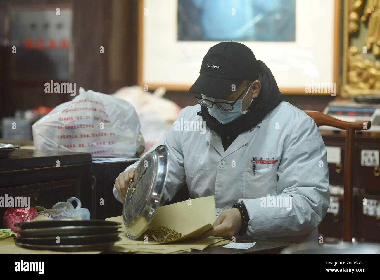 A Chinese employee dispense traditional Chinese herbal medicine (TCM