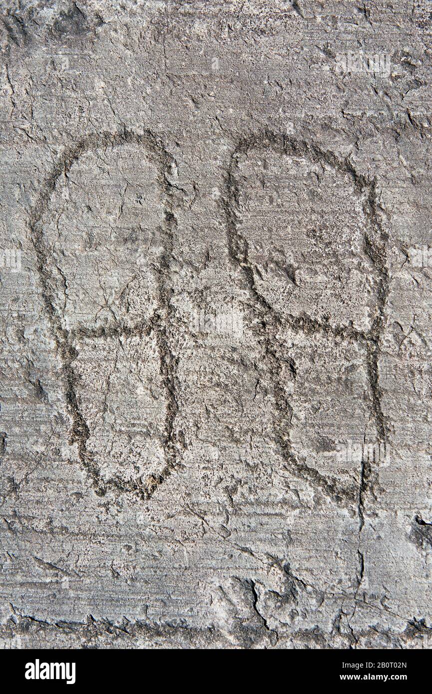 Petroglyph, rock carving, of two feet outlines. Carved by the ancient Camuni people in the iron age between 1000-1200 BC. Rock no 24, Foppi di Nadro, Stock Photo