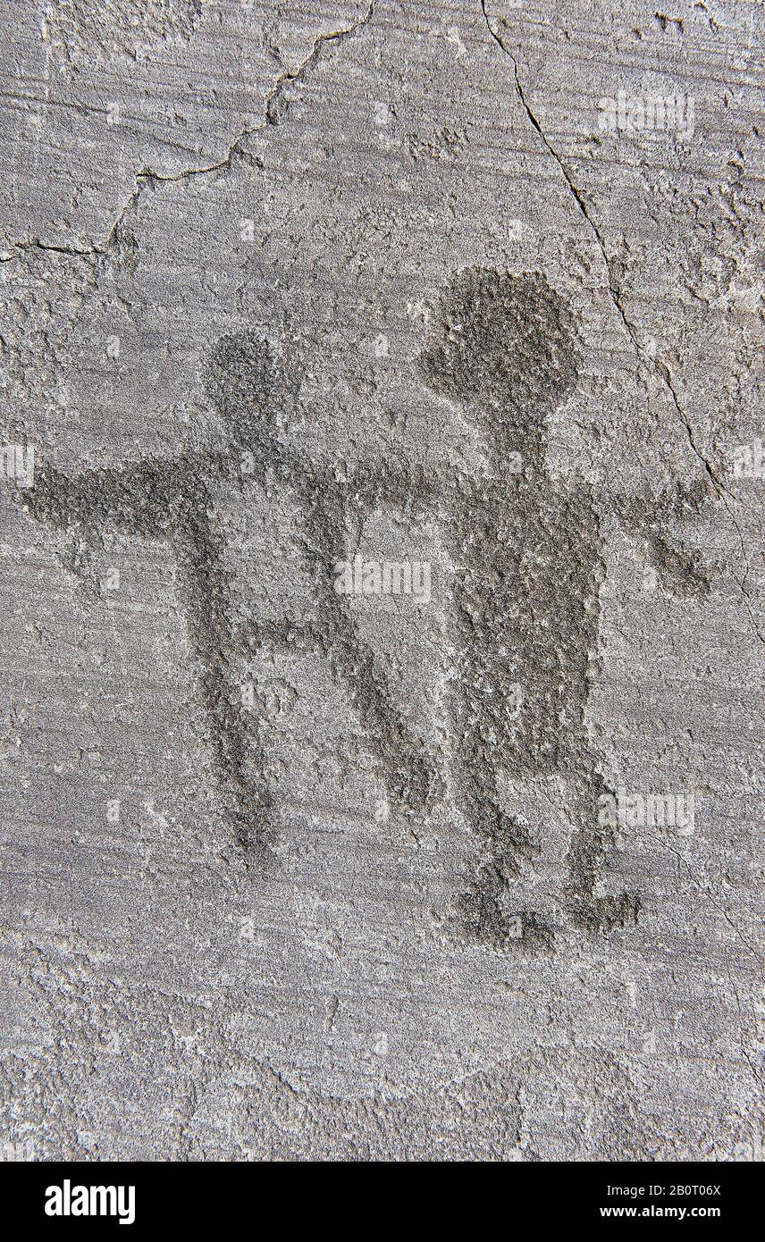Petroglyph, rock carving, of two figure. Carved by the ancient Camunni people in the iron age between 1000-1200 BC. Rock no 24, Foppi di Nadro, Riserv Stock Photo