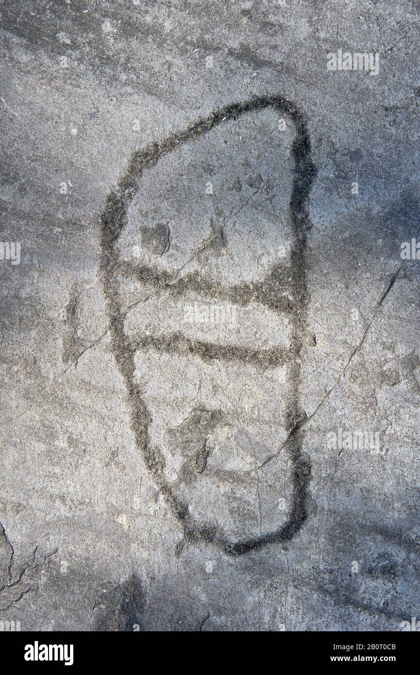 Petroglyph, rock carving, of two feet outlines. Carved by the ancient Camunni people in the iron age between 1000-1200 BC. Foppi di Nadro, Riserva Nat Stock Photo