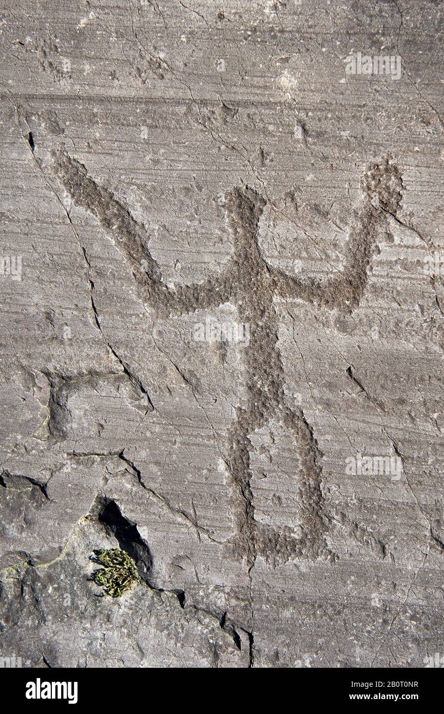 Petroglyph, rock carving, of a schematic warrior holding a shield and a sword. Carved by the ancient Camuni people in the iron age between 1000-1600 B Stock Photo