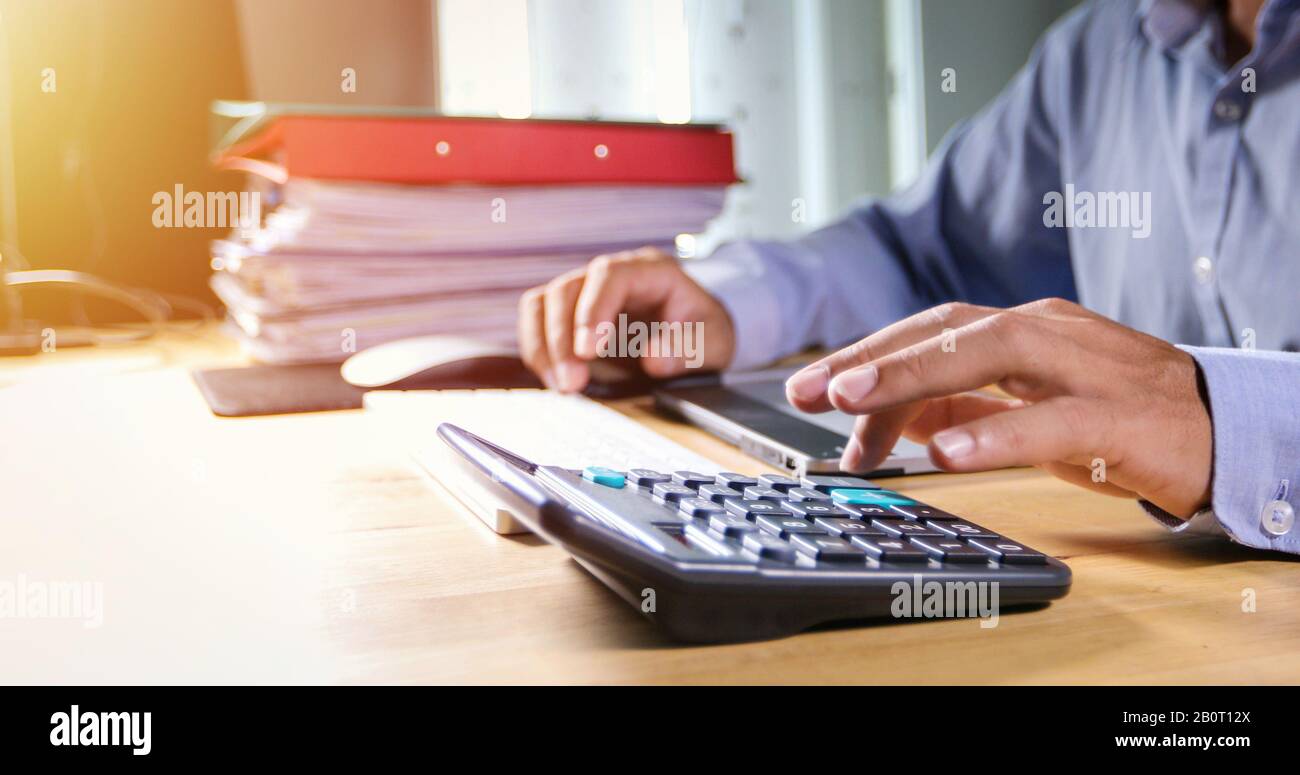 Businessmen are using calculators and analysis business data and and graph financial diagram working  at the meeting. Stock Photo