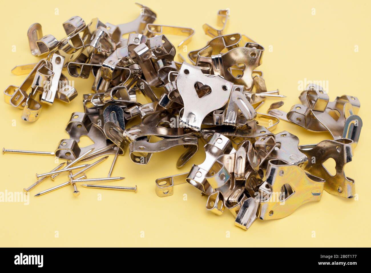 Pile of gold coloured mixed picture hanging wall fastenings Stock Photo