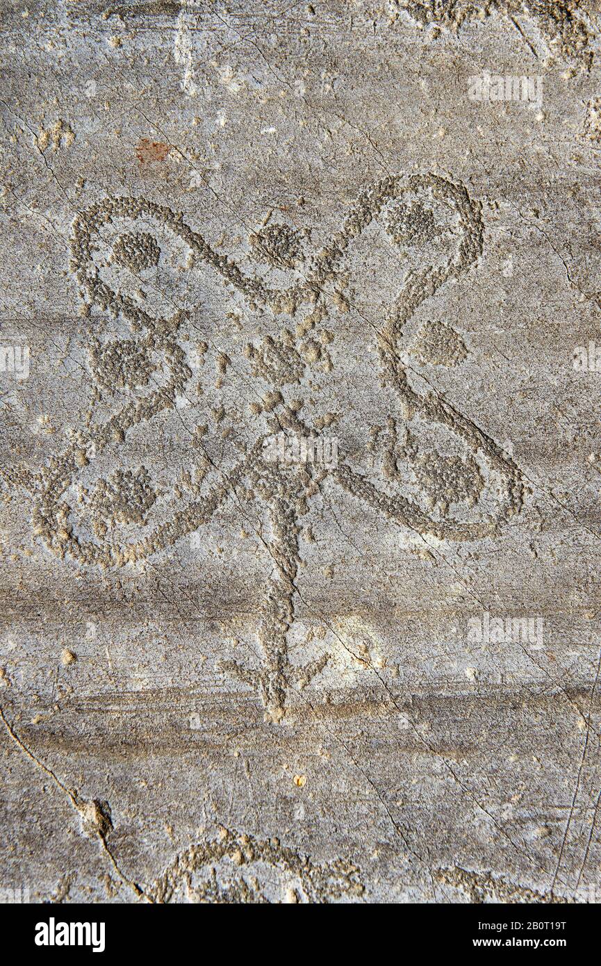 Petroglyph, rock carving, of the so called Camuni Rose, emblem of Lombardy,  named after and carved by the ancient Camunni people in the iron age betw Stock Photo