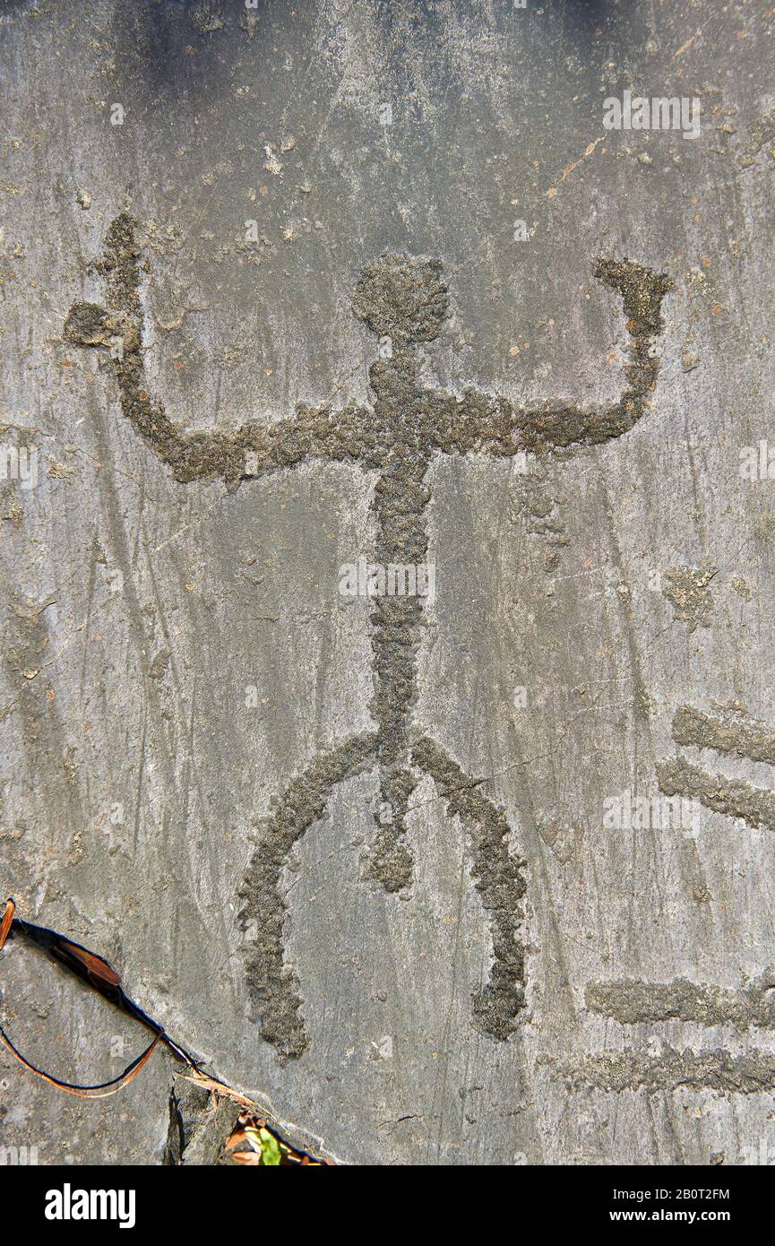 Petroglyph, rock carving, of a human figure. Carved by the ancient Camunni people in the copper age between 3200-2200 BC. Rock no 29, Foppi di Nadro, Stock Photo