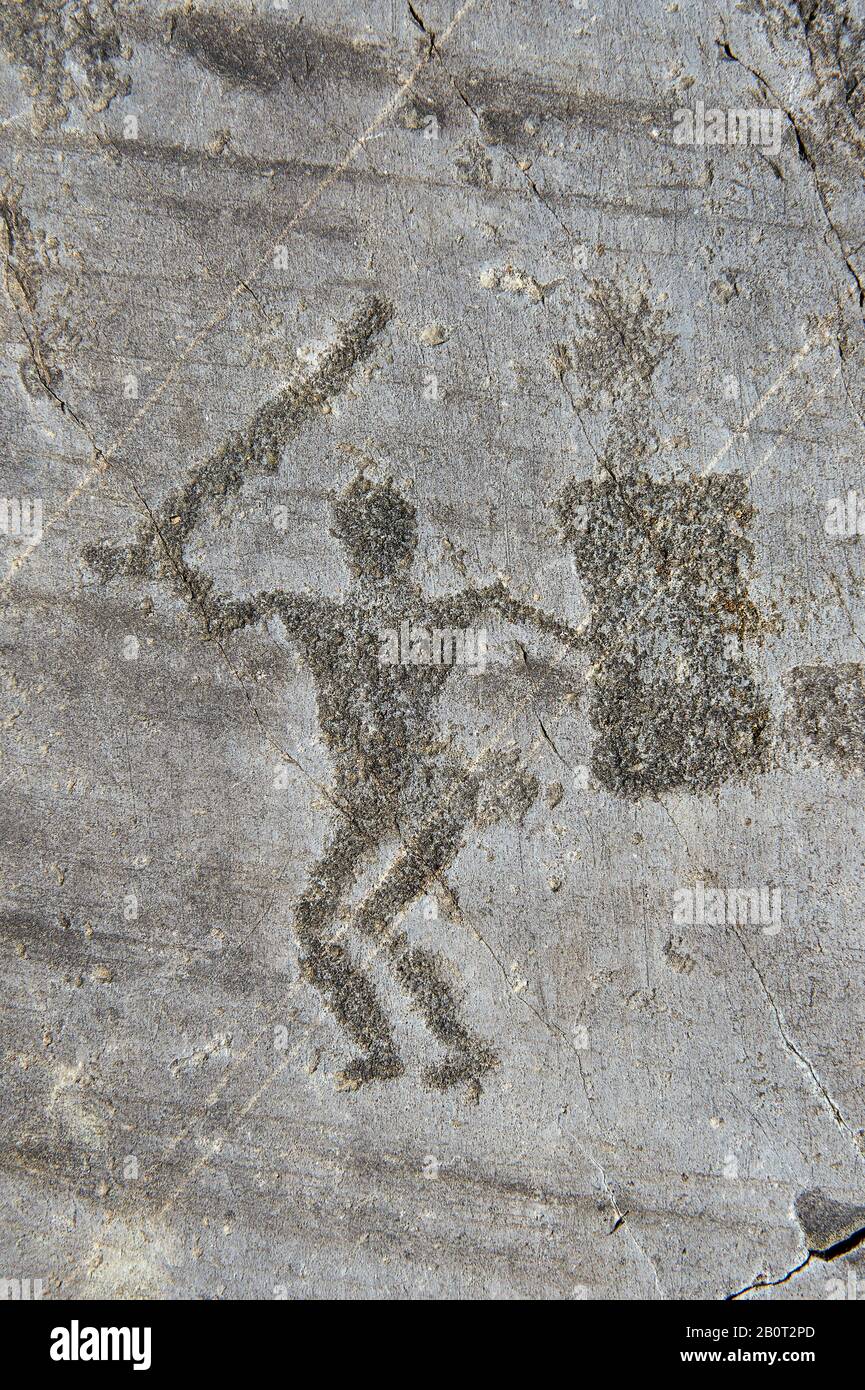 Petroglyph, rock carving, of a warriors with a shield and sword. Carved by the ancient Camunni people in the iron age between 1000-1200 BC. Rock no 24 Stock Photo