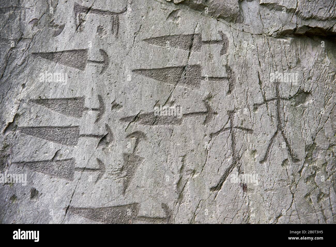 Prehistoric  petroglyphs, rock carvings, detail of of trangular daggers with semi circular pomels and schematic depictions of human figures in an anci Stock Photo