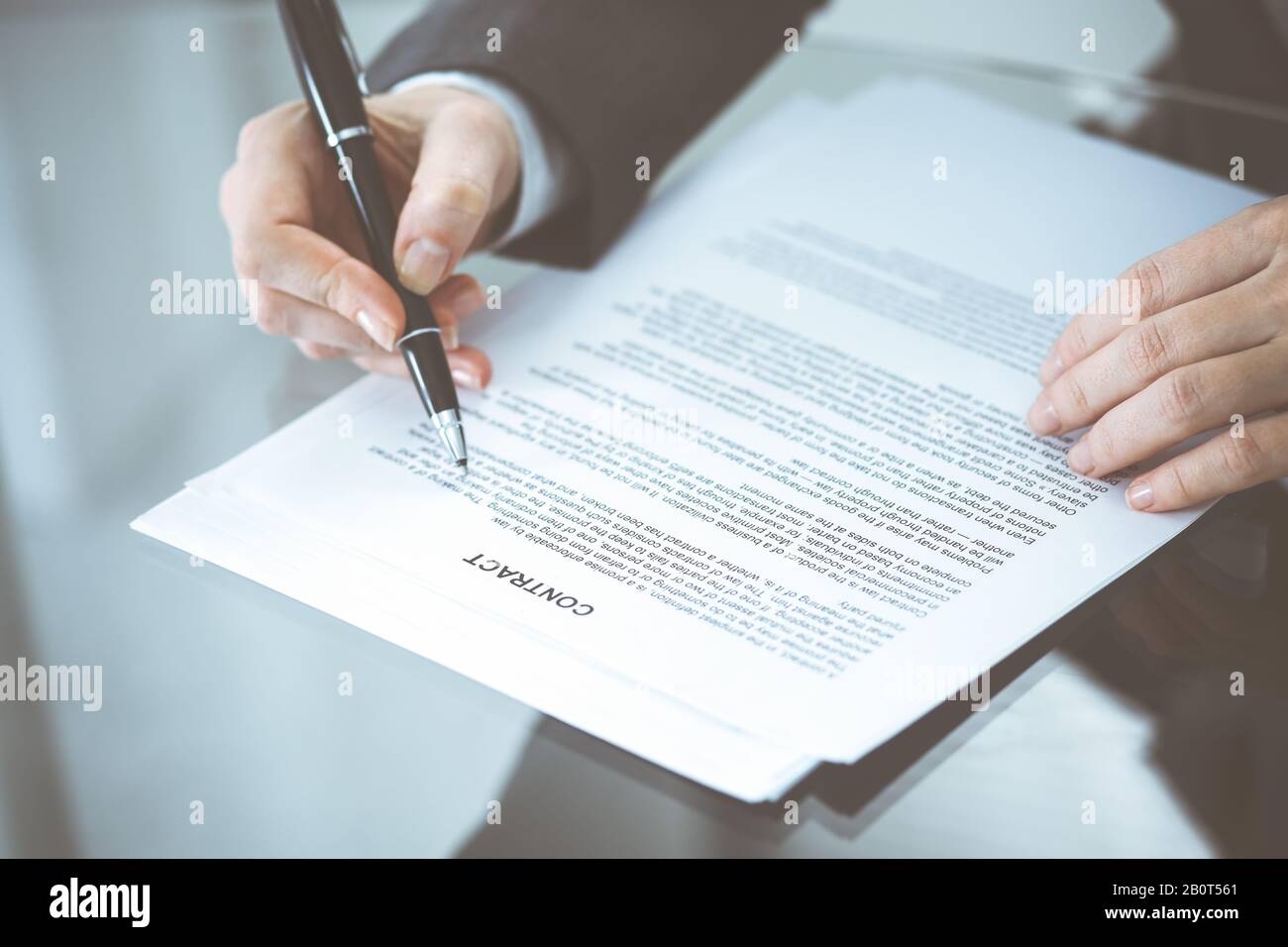 Unknown female hands with pen over document of contract. Agreement ...