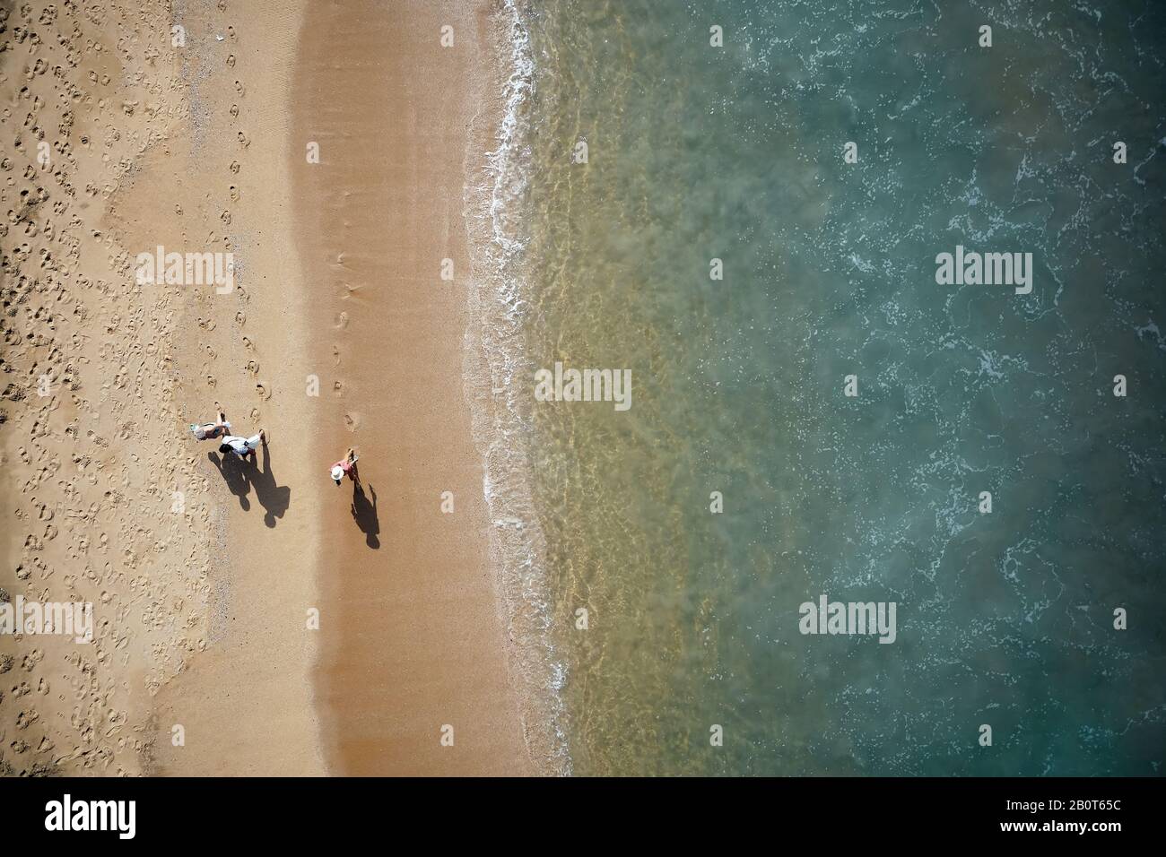 People walking along the beach. Aerial View of Waves and Azure beach ...