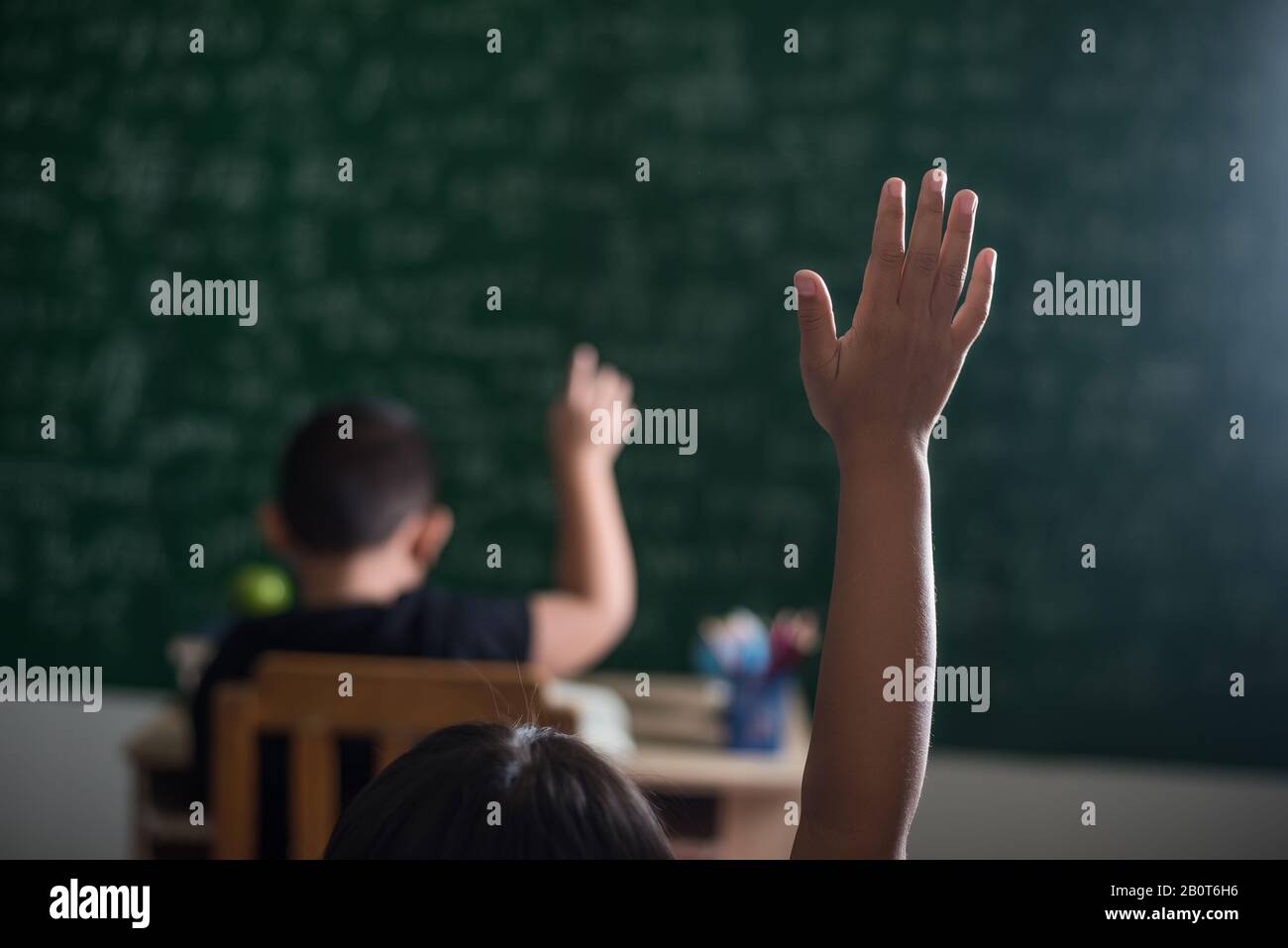 kid raising his hand in classroom Stock Photo - Alamy
