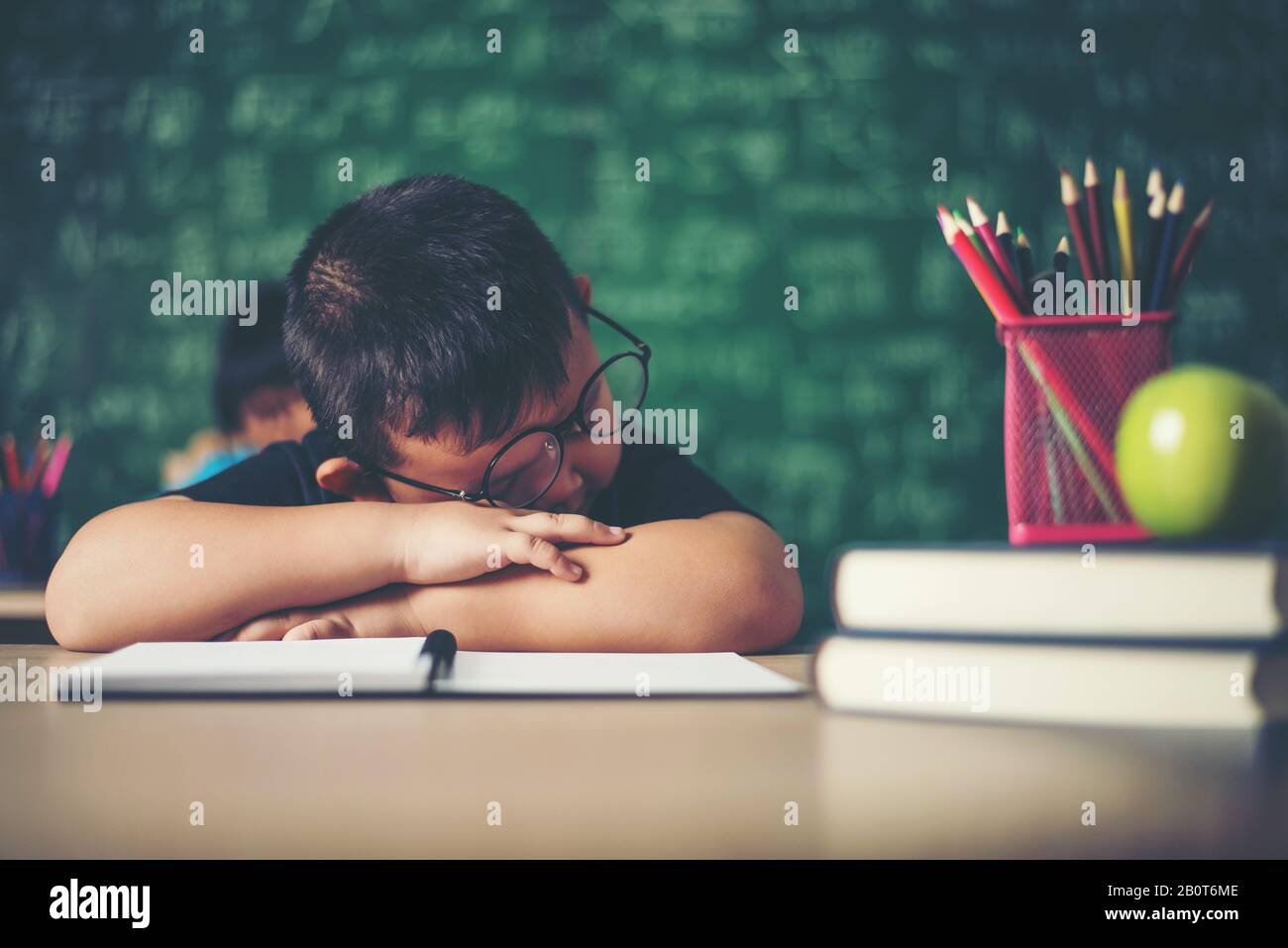 Boy sleeping on the books in the classroom Stock Photo - Alamy