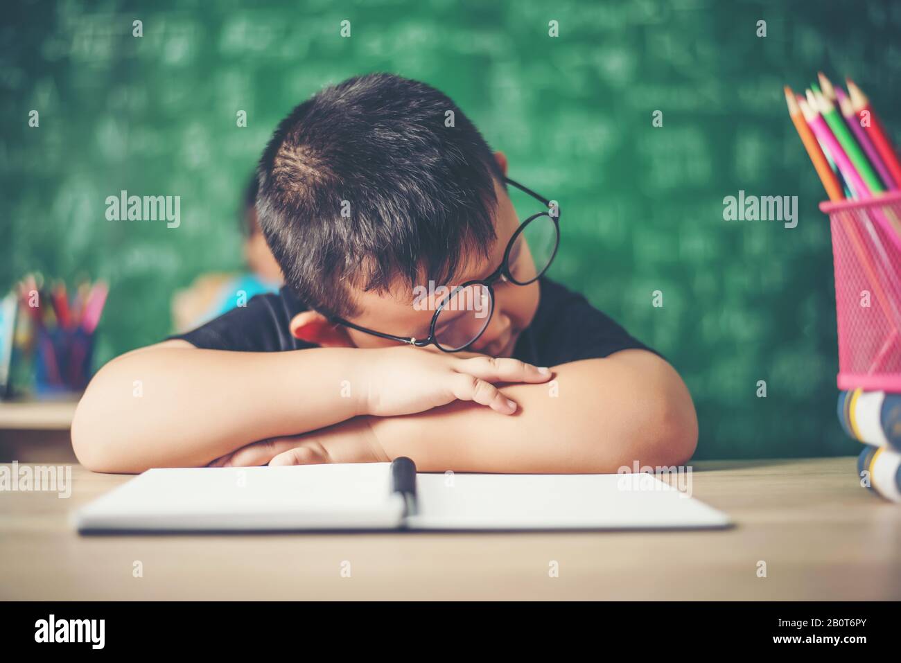Boy sleeping on the books in the classroom Stock Photo - Alamy