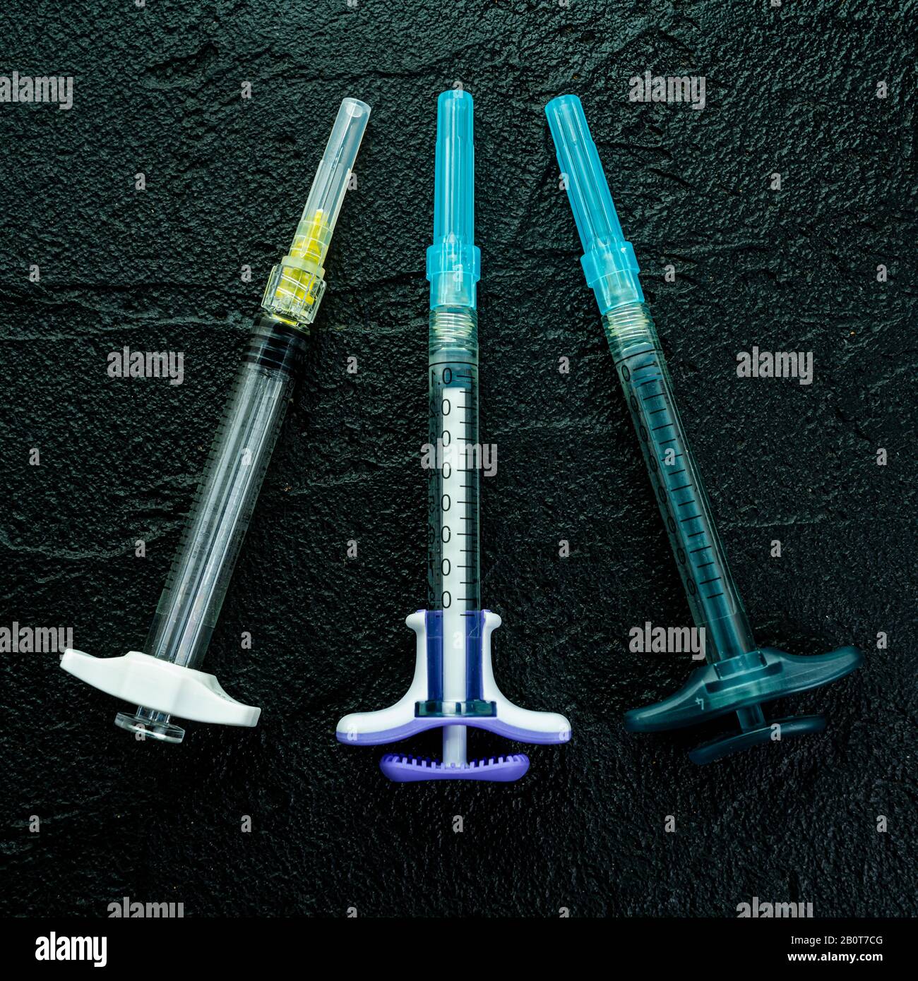 cosmetology injections. Plastic syringe on black background. Medical