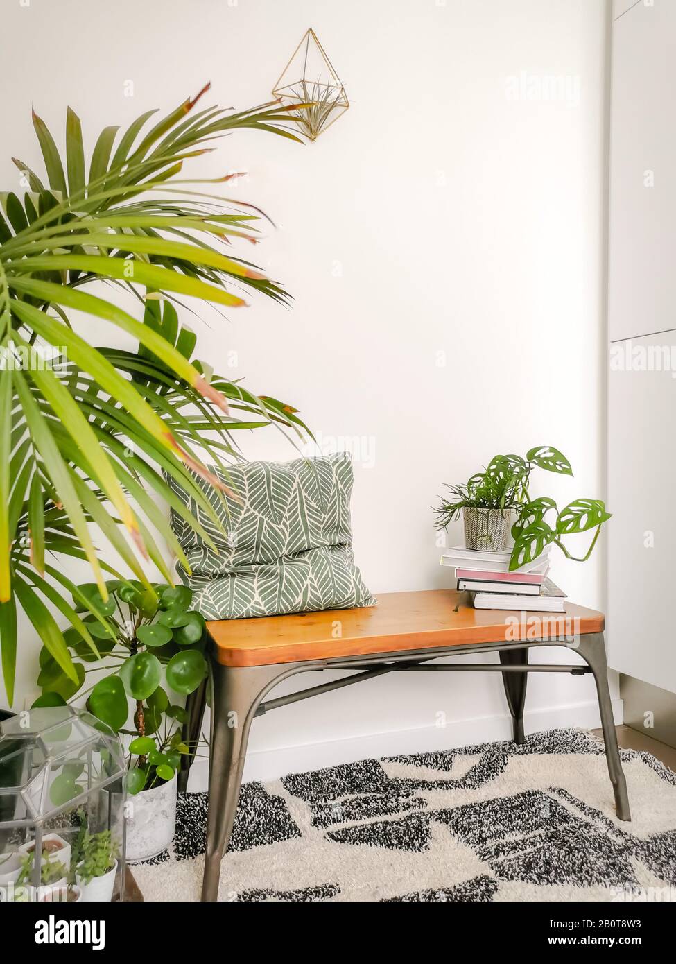 Small seating nook in Scandinavian design with lots of natural bright light and green houseplants creating a green oasis for relaxing Stock Photo