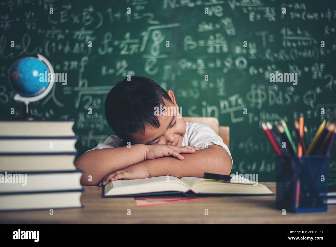 Boy sleeping on the books in the classroom Stock Photo - Alamy