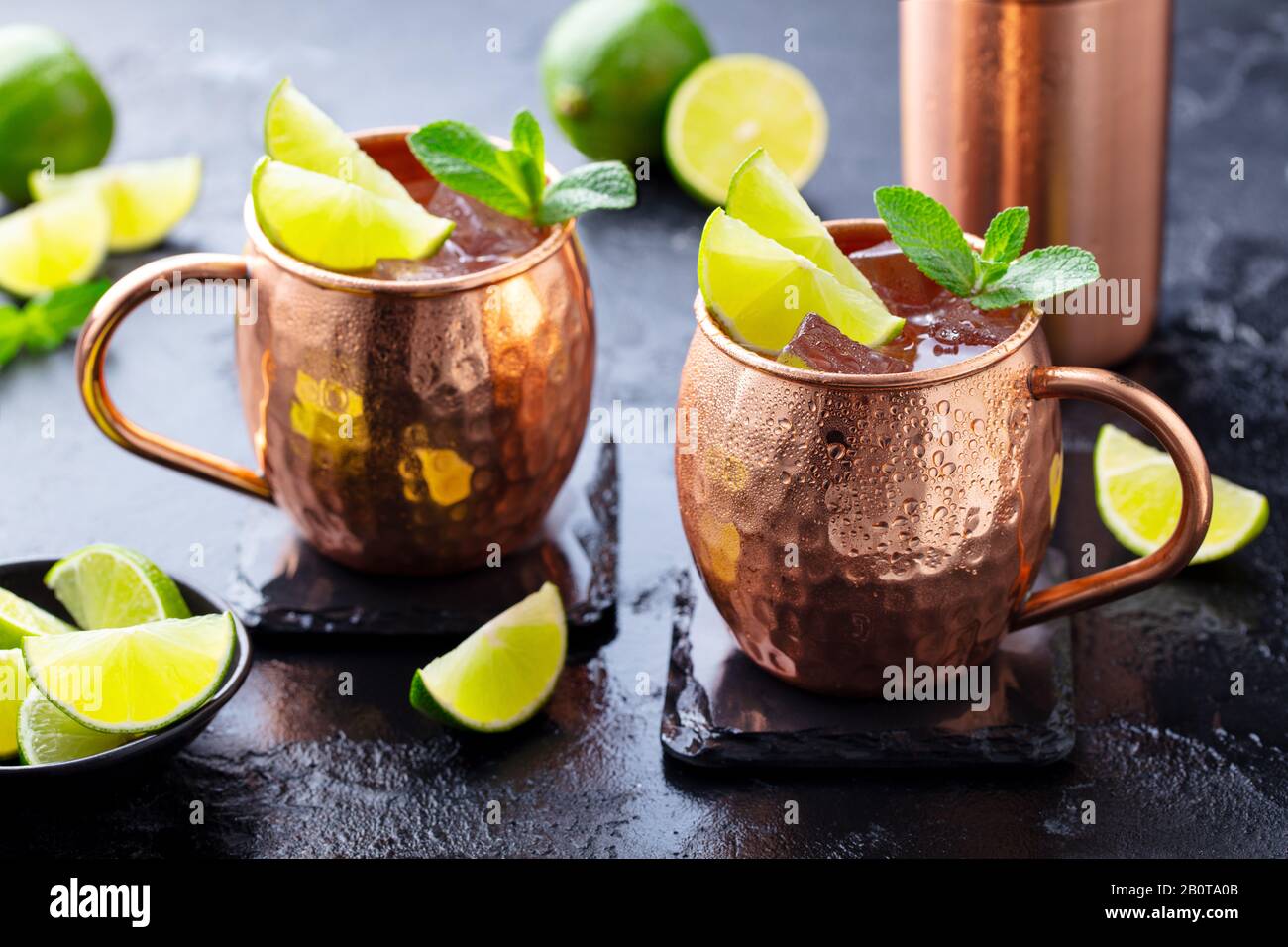 Moscow Mules cocktail with ginger beer, vodka, lime and mint. Dark background. Close up. Stock Photo