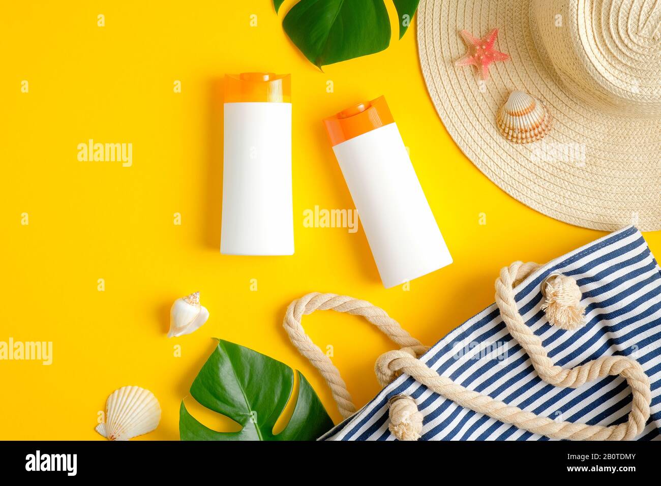 Suntan or sunblock lotions packages on yellow background with beach bag