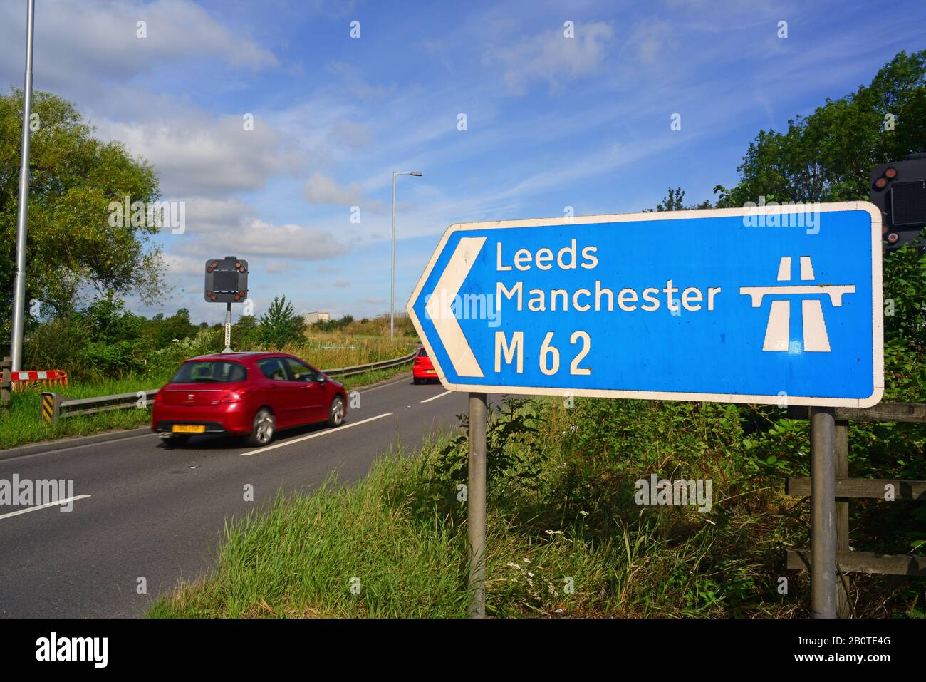 traffic passing m62 motorway sign to leeds and manchester at normanton junction leeds yorkshire uk Stock Photo